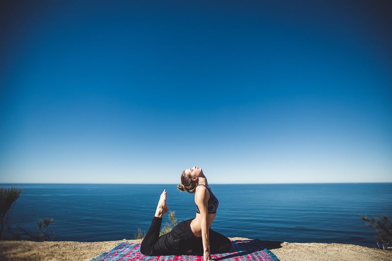 Woman practicing yoga on a beach